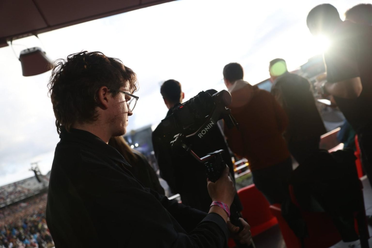 camera operator filming live music crowd